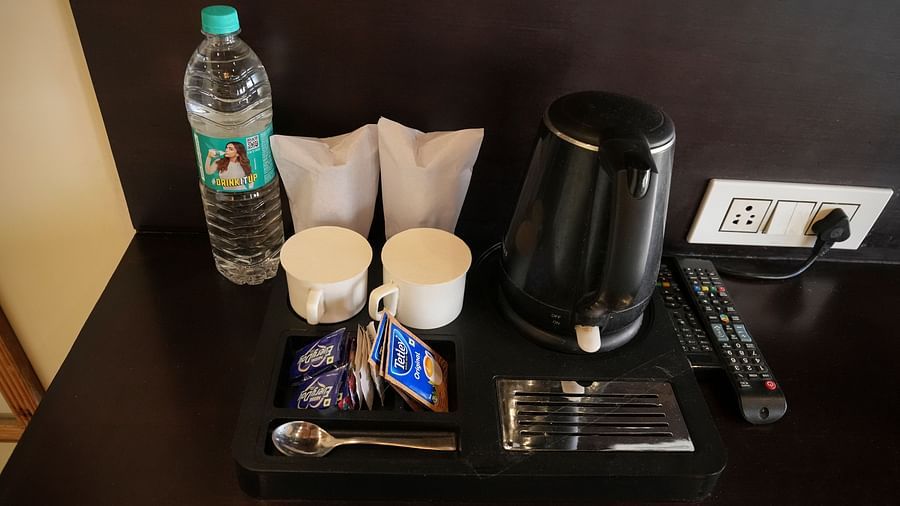 A bunch of sachets for tea and coffee, a water bottle, an electric kettle, etc